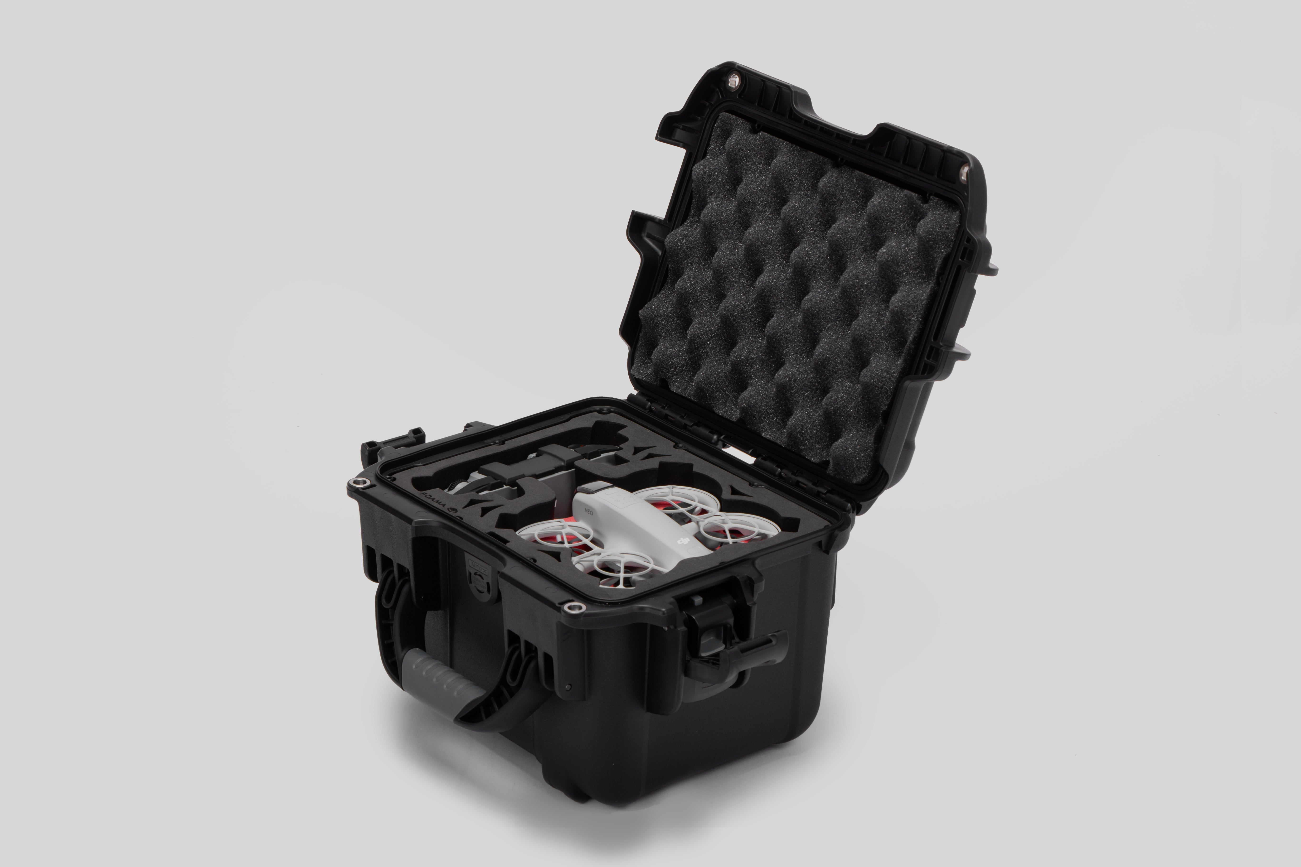 Angled view of DJI Neo Black Color Adventure Ready Compact Waterproof Carry-on Case and Custom Foam Insert with a Red Layer, holding the DJI Neo Fly More Combo